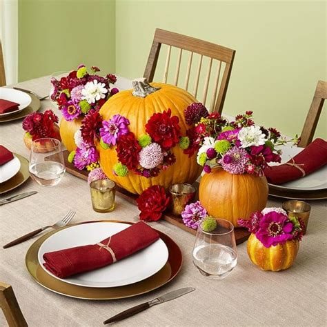 Harvest dining setup with glowing amber glass votives tall taper candles and dark teak tabletop