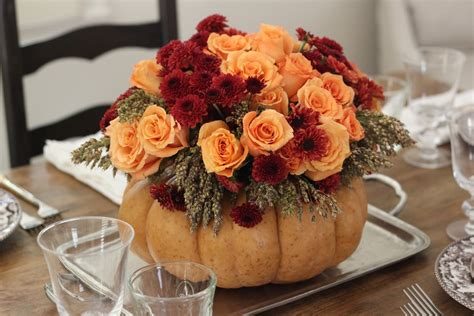 Farmhouse dining table styled with a wooden planter box red berries and glowing pillar candles