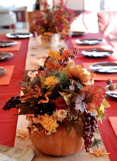 Open concept dining area featuring a lush dried botanical garland down a long oak table