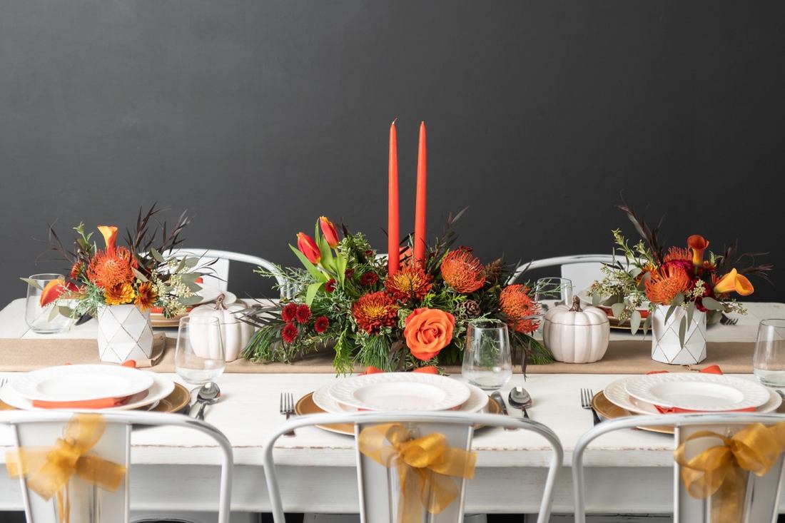 Casual family dining table featuring a chunky knit runner heirloom squash and votive lights
