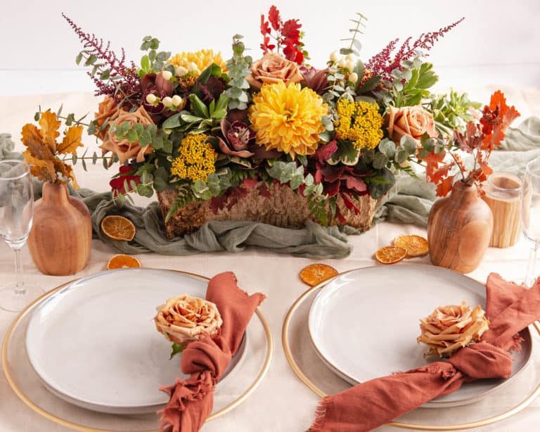 Rustic elegant dining setup with layered jute and linen runners paired with tied wheat sheaves