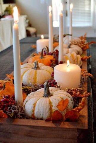 Glossy magnolia leaves showing velvet brown undersides around clear glass hurricane candles.