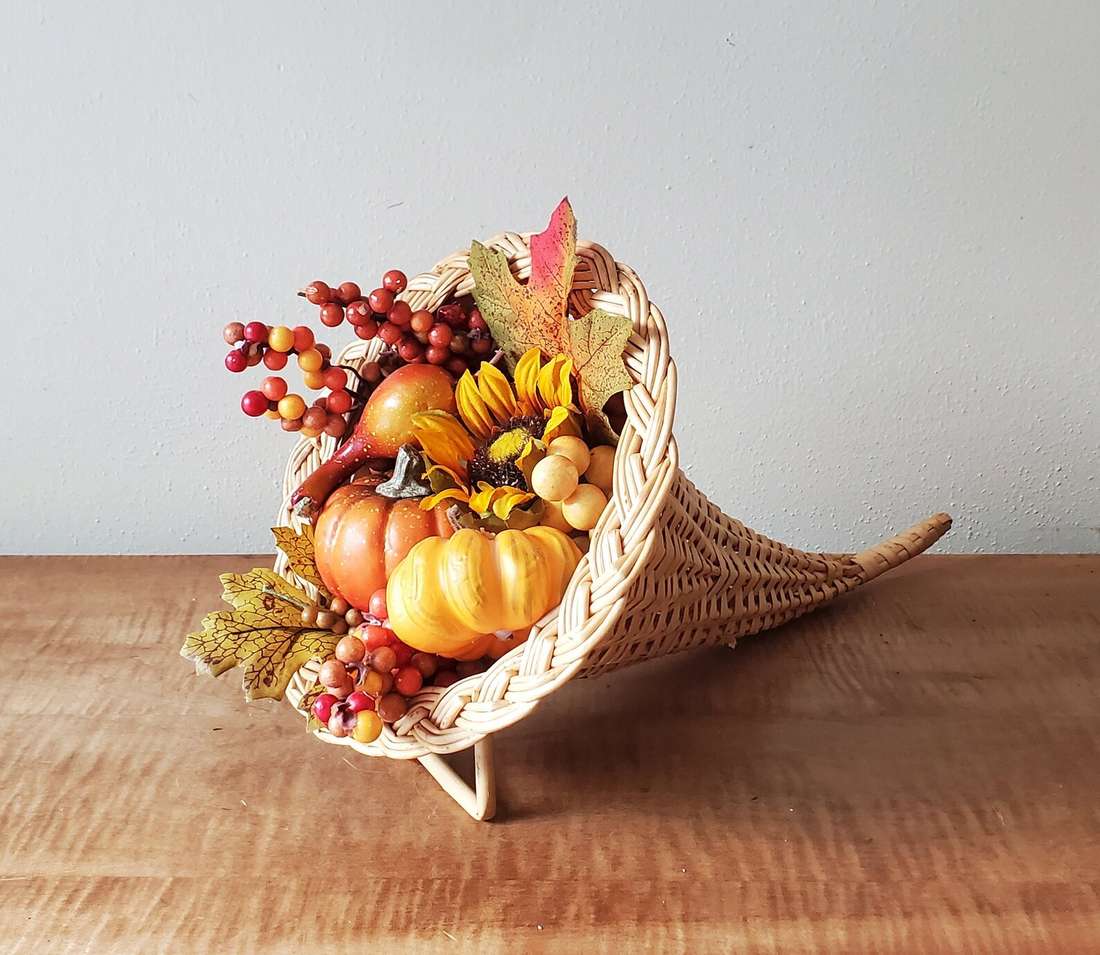 Live edge wooden slab holding hollowed mini pumpkins transformed into candle holders.