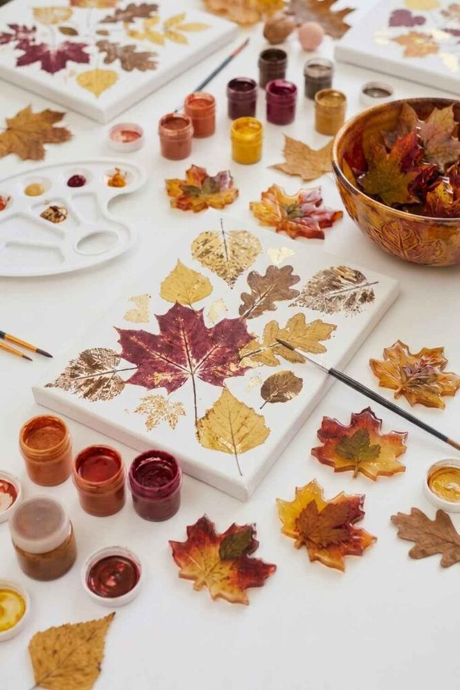 Plush velvet handmade pumpkins clustered along a eucalyptus garland on a dining table.