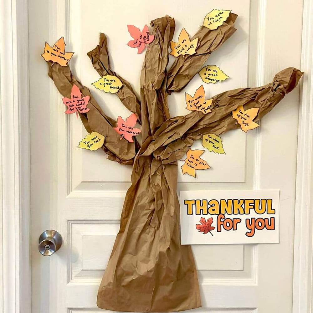 Crafty pinecone turkeys with felt feather accents holding name cards for Thanksgiving dinner.