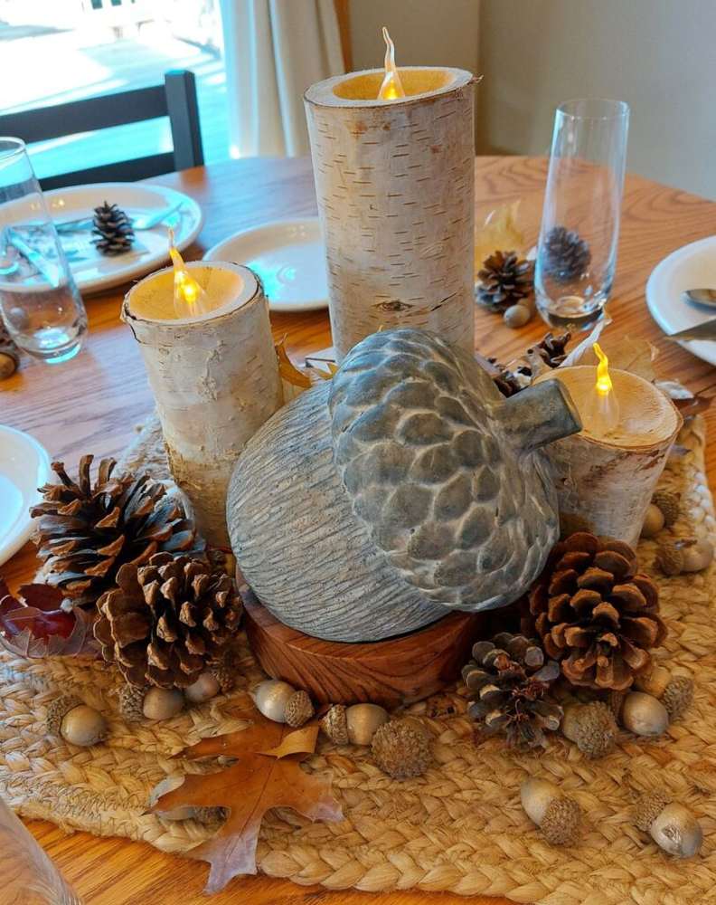 Elegant glass cloche encasing mini velvet pumpkins pinecones and glowing fairy string lights.
