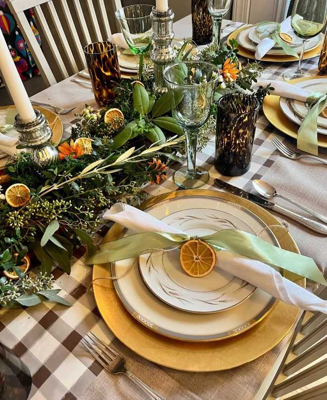 Elegant banquet, deep green velvet ribbon, dried citrus slices, twinkling fairy lights, dark wood table