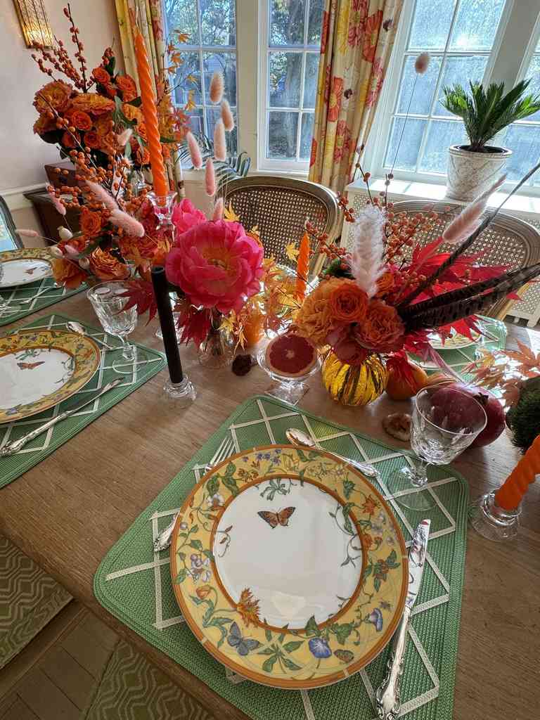 Bright dining room, orange rose arrangement, butterfly‑shaped plates, pastel table runner, natural light.