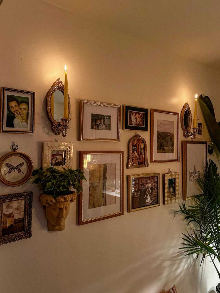 Dimly lit room with vintage salon mirrors and candle sconces creating an intimate atmosphere.