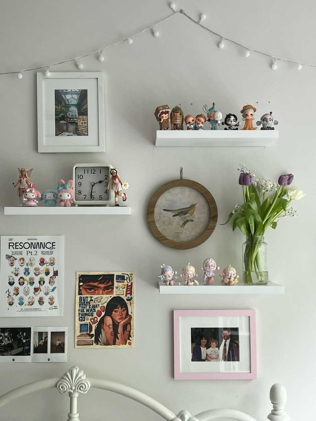 White floating shelves displaying anime figures and a large wall clock in a study.