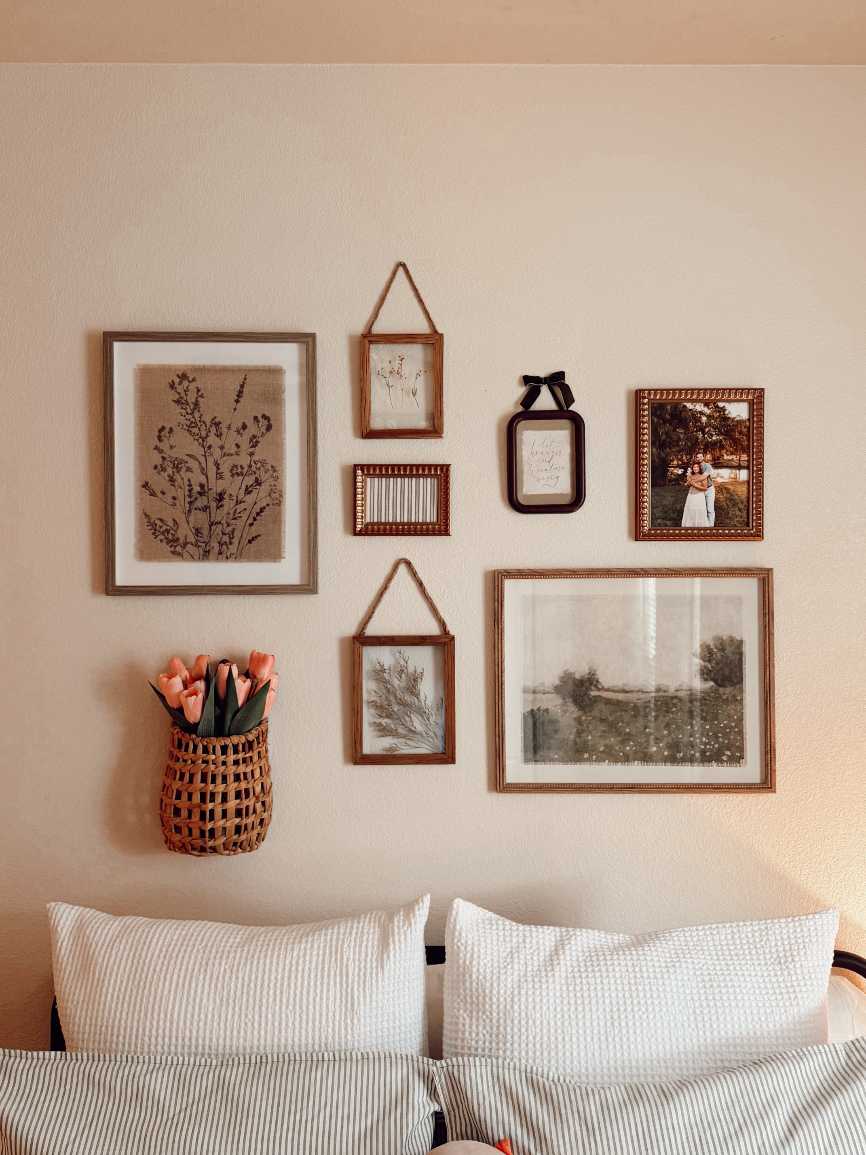 Wall of framed pressed botanicals and a woven basket in a rustic living room.