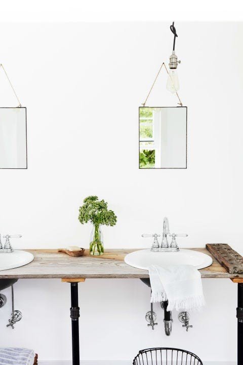 White bathroom design ideas featuring double vessel sinks, wall-mounted faucets, floating vanity, and round mirrors