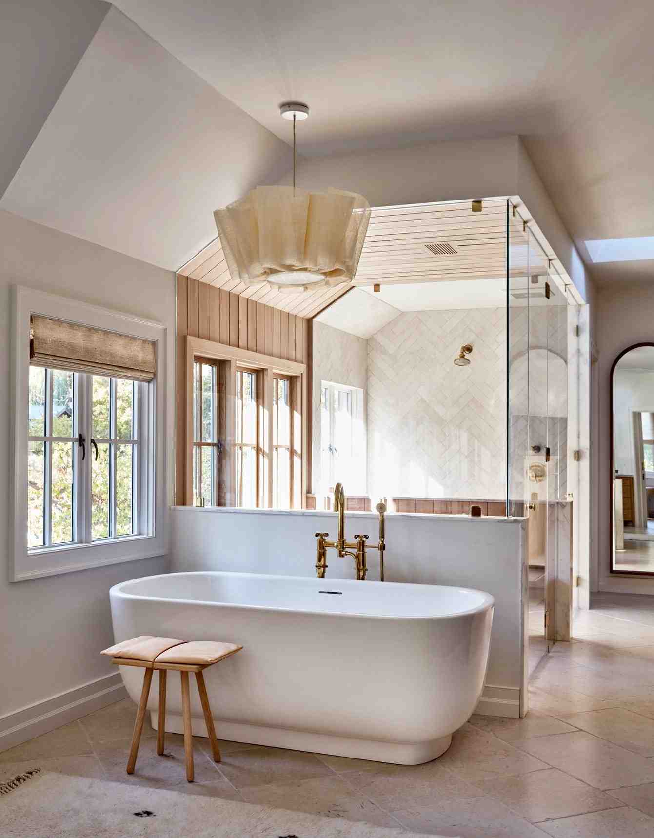 Contemporary white wet room featuring freestanding tub, curbless walk-in shower, subway tile, and recessed lighting
