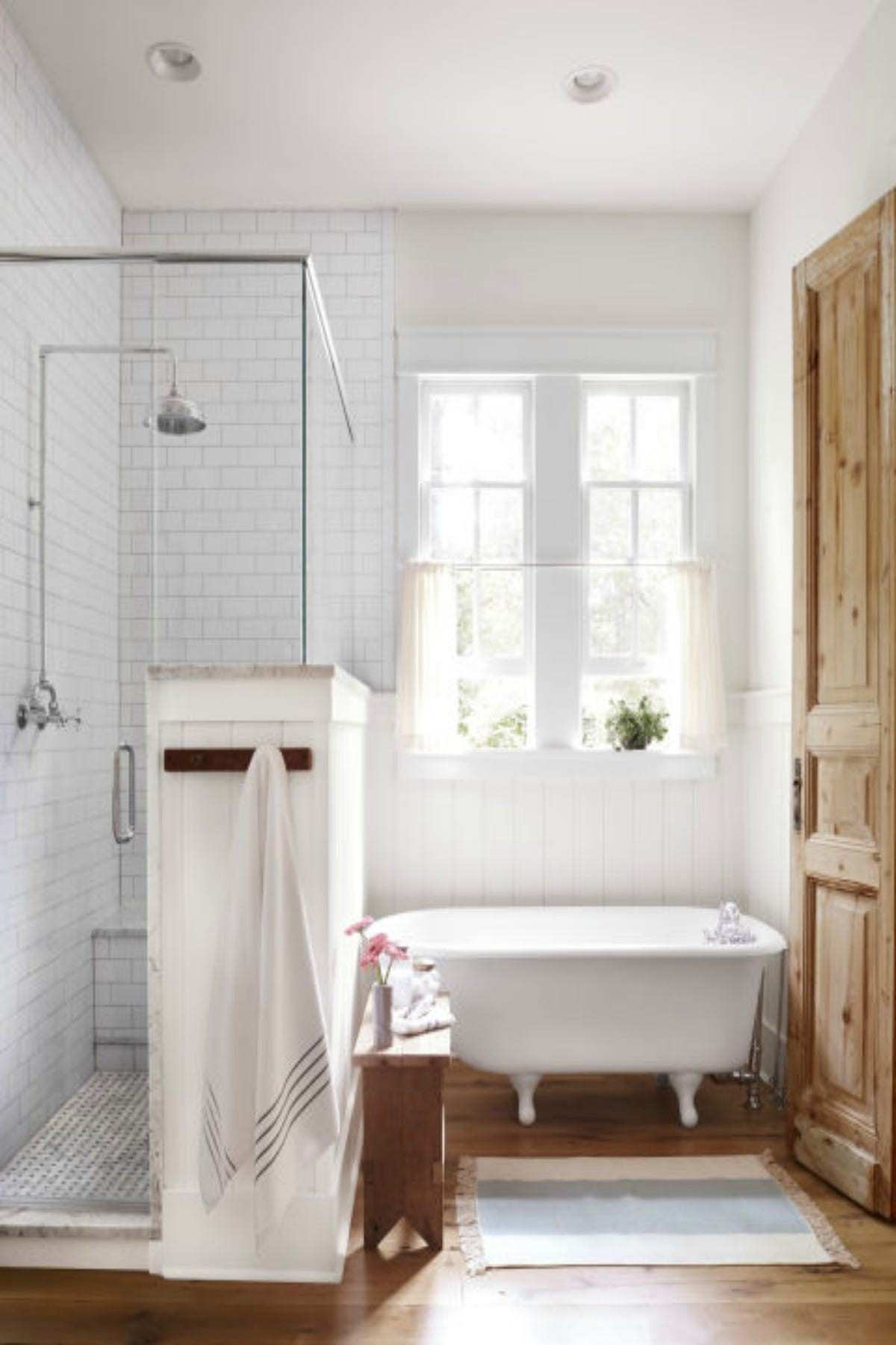 Traditional white bathroom design ideas showcasing a white clawfoot bathtub with an overhead circular shower curtain ring.