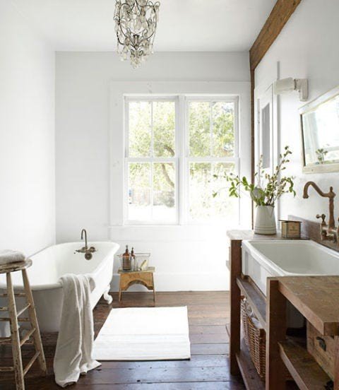 Luxury white bathroom design ideas featuring a white bathtub contrasting against a rich dark walnut wood vanity.