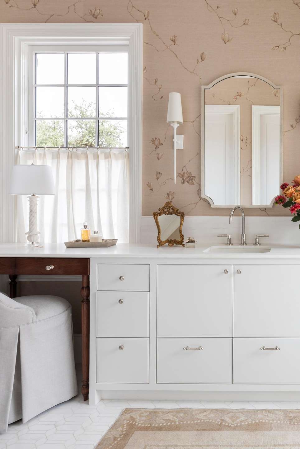 Romantic white bathroom design ideas with a white double vanity against soft floral patterned wallpaper background.
