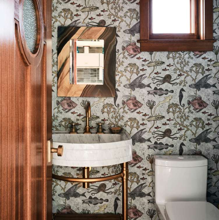 Statement white bathroom design ideas featuring a white ceramic vessel sink against subtle textured white wallpaper.