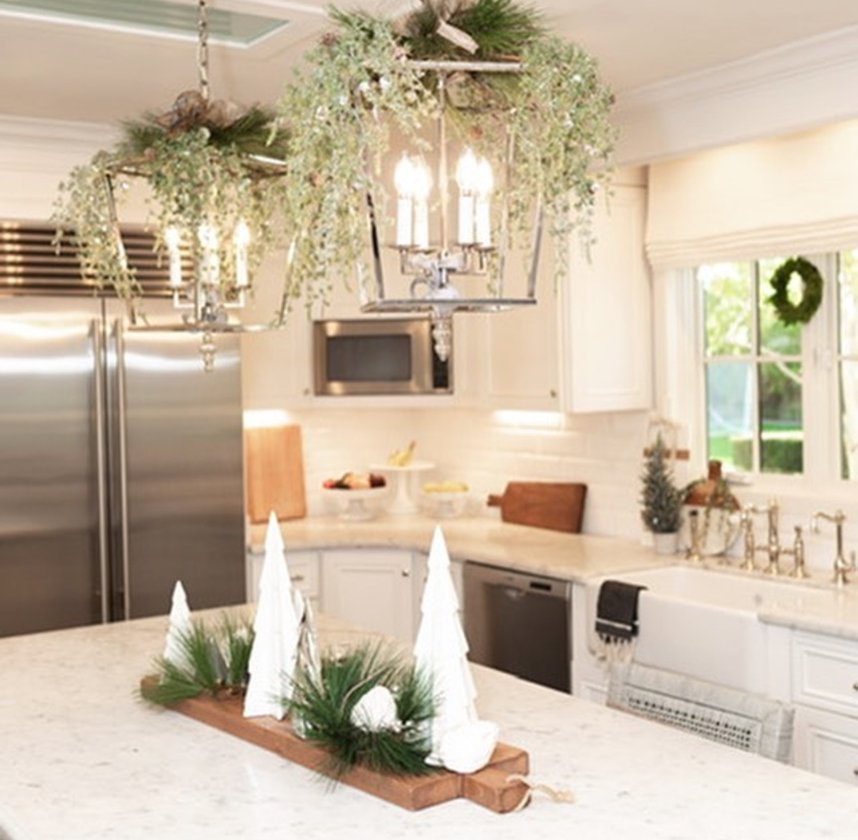 White ceramic trough filled with snow and small ornaments on the kitchen island.