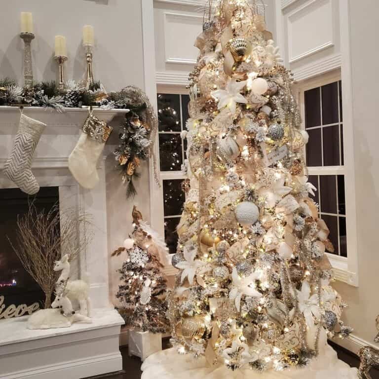 Formal living room featuring white gold ribbon tree beside marble mantel under crystal chandelier illumination