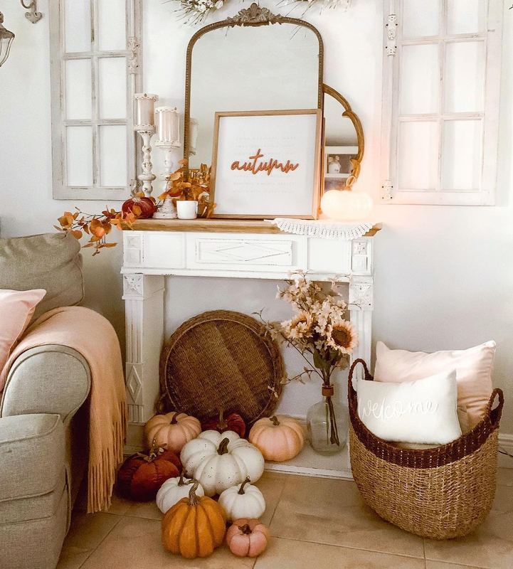 living room with white mantel, autumn print, floor pumpkins, basket, natural wood, soft lighting