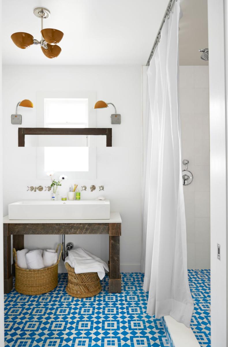 Crisp white bathroom vanity sitting atop intricate blue and white patterned encaustic floor tiles.