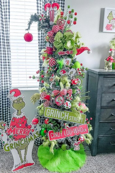 Playful tree with wooden Whoville signs and red accents in a bright living room