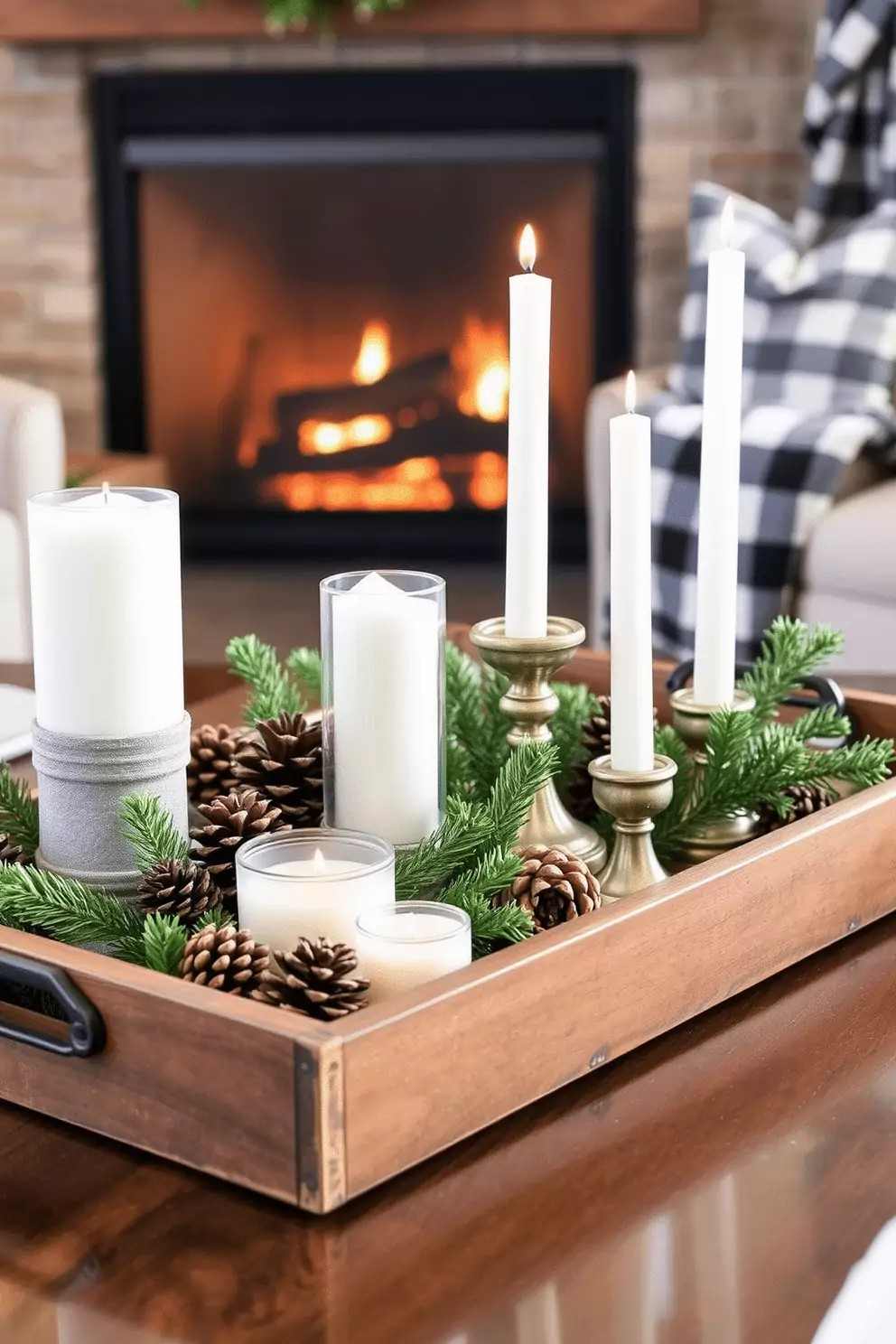 Rustic carved wooden tray with glass pillar candle hurricanes pinecones and greenery by stone fireplace