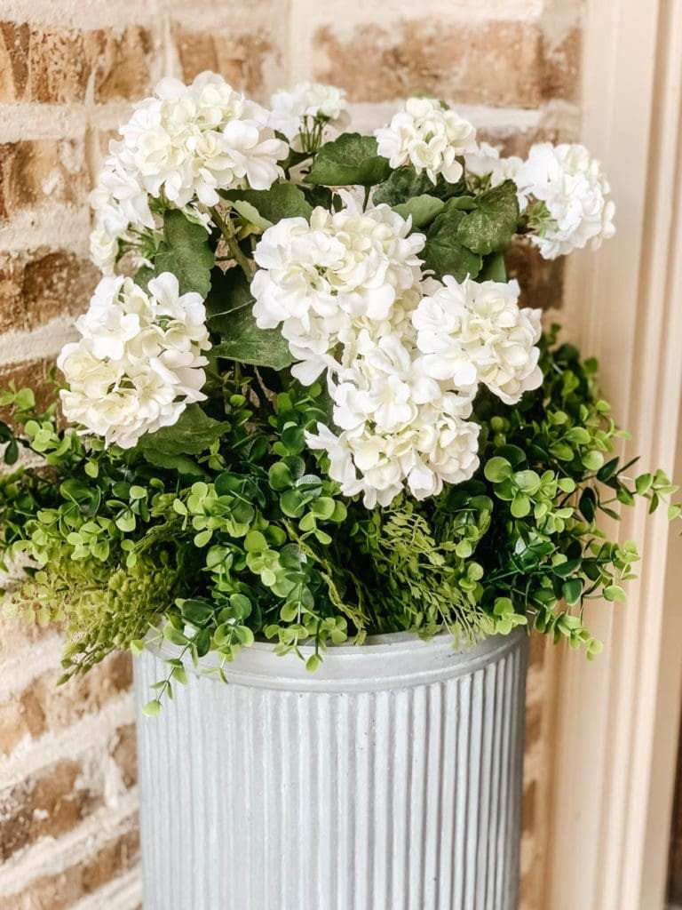 Dried white winter flowers in a rustic galvanized metal vase