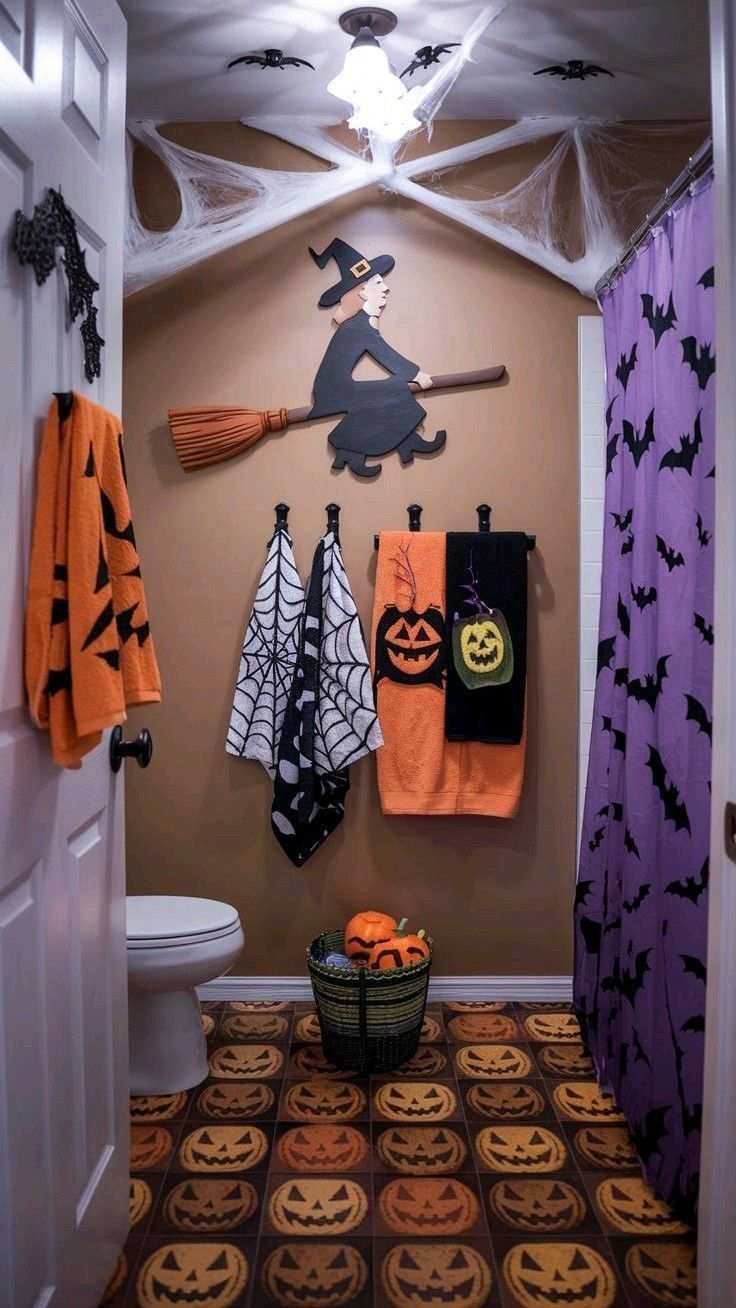 Bathroom with purple shower curtain, witch silhouette, jack‑o‑lantern vanity light, matte black fixtures.