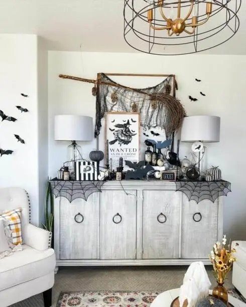 Sideboard with a wanted crone sign and a witch broom.