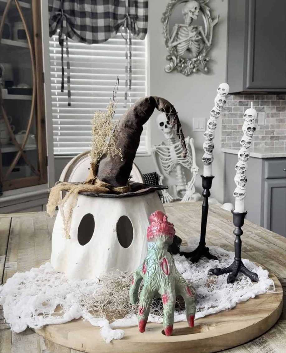 Dining table with zombie hands, skull candles, and dark linens.