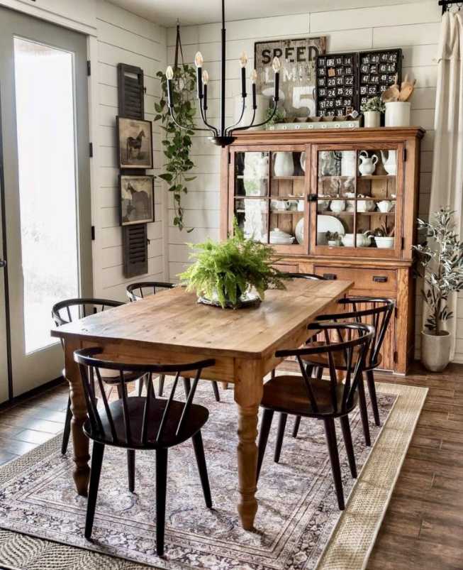 Dining room with solid wood table, glass-front china cabinet, vintage chandelier, soft linens.