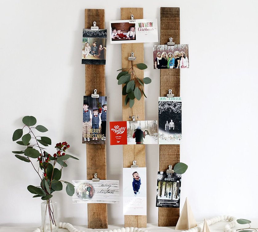 Solid dark walnut wooden board with horizontal brass wire rows displaying festive cards on wall