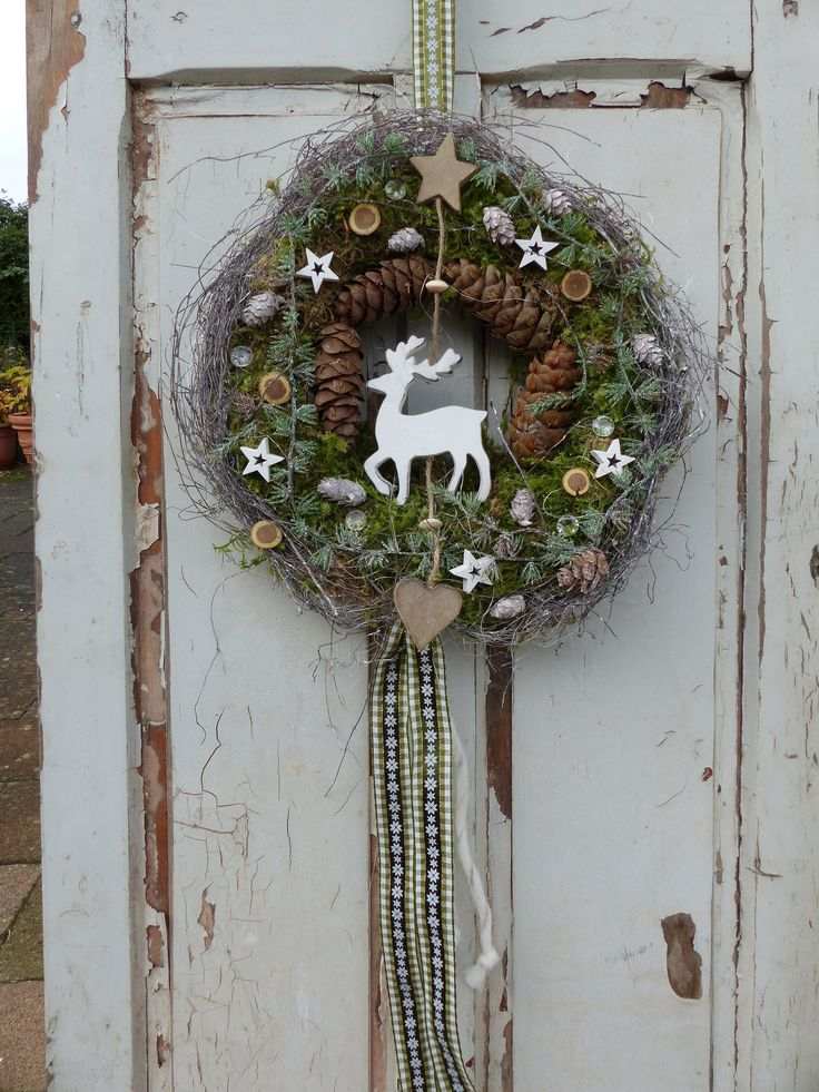 A charming woodland wreath with pinecones, stars, and a reindeer centerpiece.