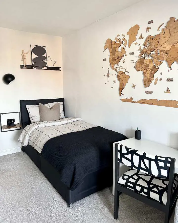 Bedroom with a large world map wall art above crisp white bedding and travel‑inspired accessories.